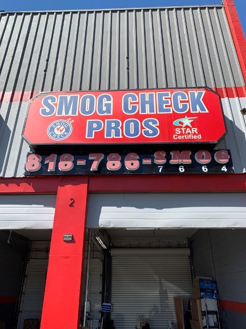 A sign on the side of a building that says smog check pros